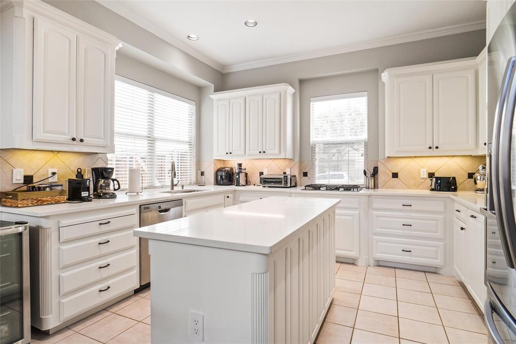 984 East Bethel School Road Coppell, TX 75019 - Photo 12 of 37 a kitchen with granite countertop white cabinets and white appliances