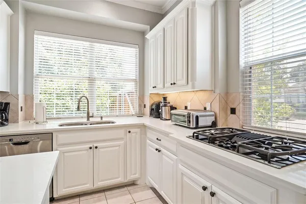 a kitchen with white cabinets and a stove top oven