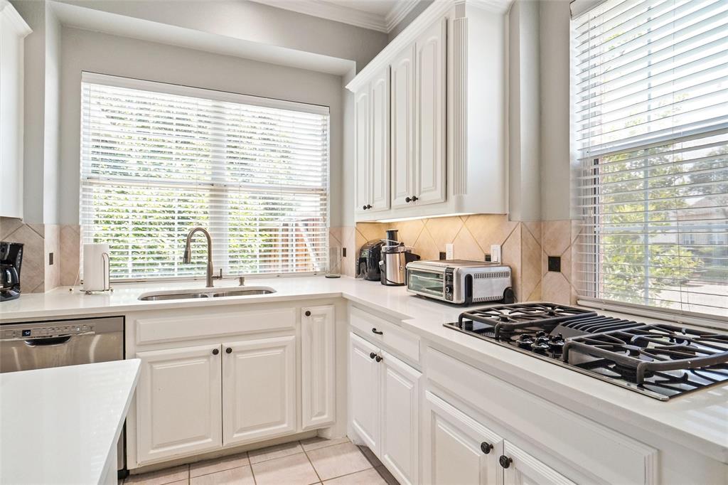 984 East Bethel School Road Coppell, TX 75019 - Photo 13 of 37 a kitchen with white cabinets and a stove top oven