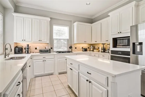 a kitchen with cabinets appliances a sink and a window