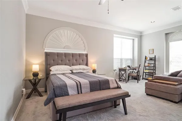 a bedroom with a bed a couch and a chandelier