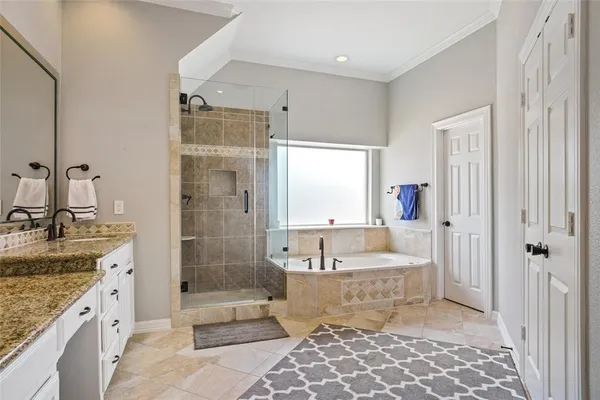 a bathroom with a granite countertop tub sink shower and mirror