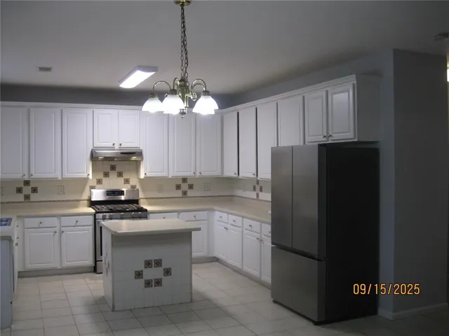 a kitchen with a sink a stove a refrigerator and cabinets