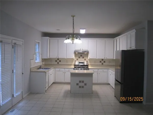 a kitchen with kitchen island granite countertop appliances cabinets and a counter top space
