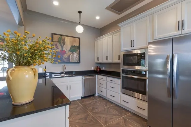a kitchen with stainless steel appliances granite countertop a sink a stove and a refrigerator