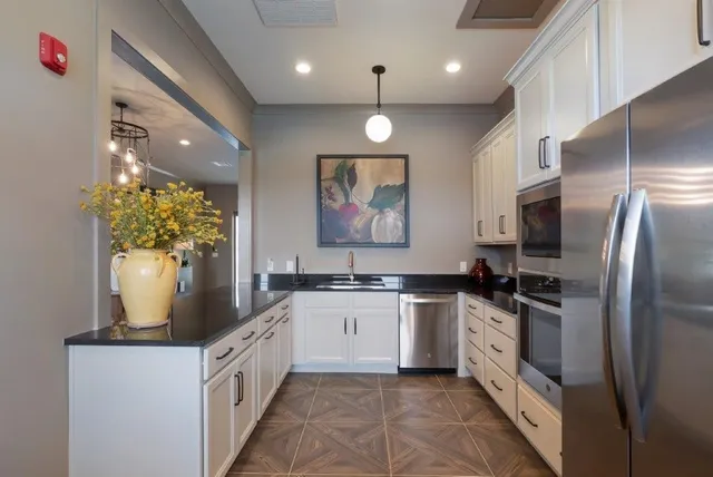 a kitchen with stainless steel appliances granite countertop a stove a sink and a refrigerator