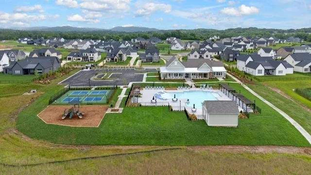 an aerial view of residential houses with outdoor space and parking