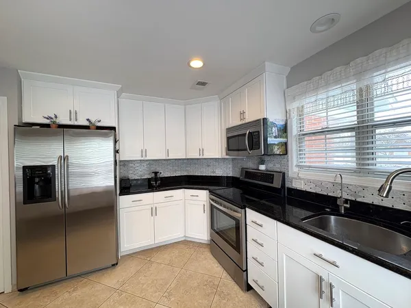 a kitchen with granite countertop a sink and stainless steel appliances