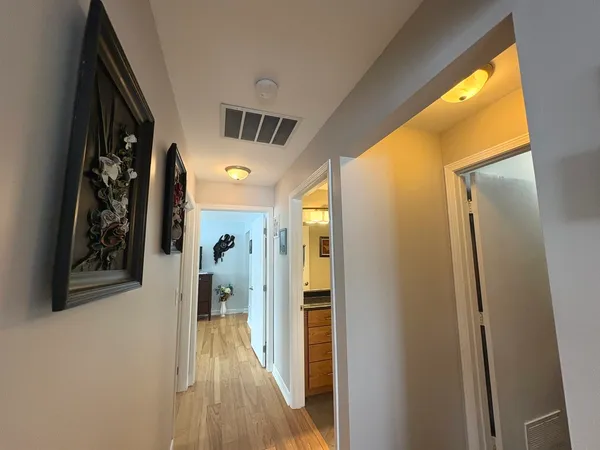 a view of a hallway with wooden floor and stairs