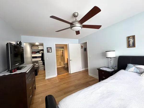 a bedroom with a bed and a flat tv screen on a dresser