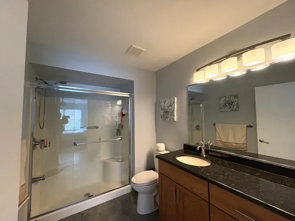 a bathroom with a granite countertop sink toilet and shower