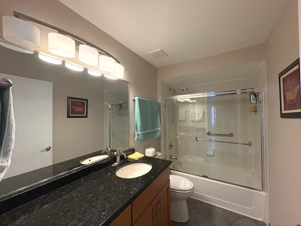 a bathroom with a granite countertop sink toilet and shower