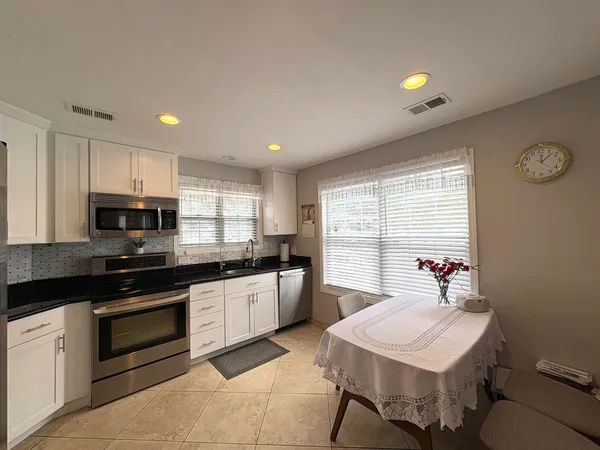 a kitchen with a sink a stove a microwave and cabinets