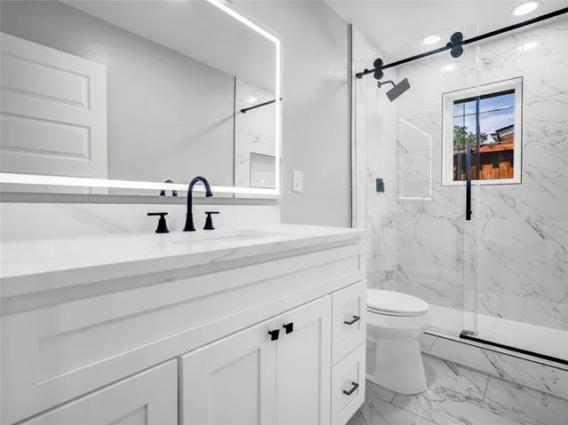 a bathroom with a sink a toilet and shower