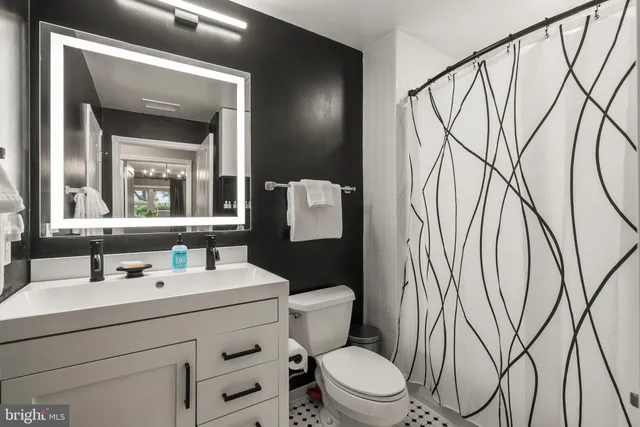 a bathroom with a toilet sink and mirror