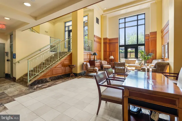 a dining room with furniture and a floor to ceiling window