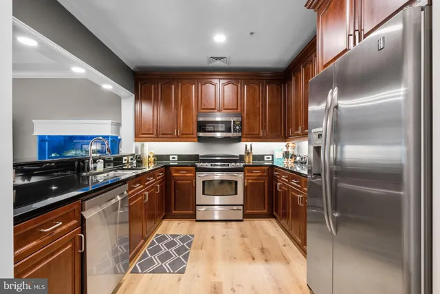 a kitchen with granite countertop stainless steel appliances and wooden cabinets