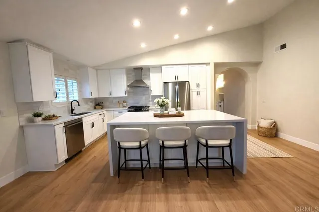a kitchen with a dining table chairs and white cabinets