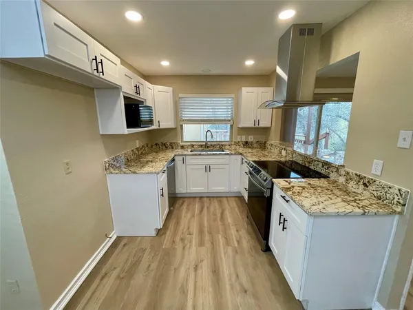 a kitchen with a sink stove top oven and cabinets