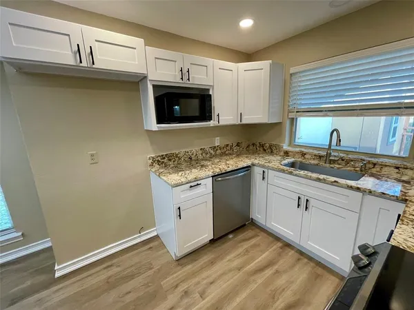 a kitchen with stainless steel appliances granite countertop a sink stove and microwave