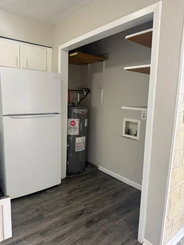 a white refrigerator freezer and a wooden floor in a kitchen