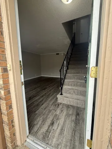 a view of entryway and hall with wooden floor