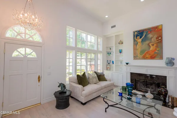 a living room with furniture a fireplace and a chandelier