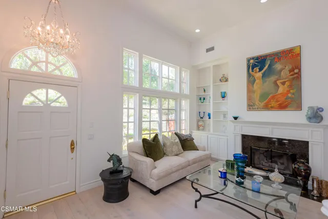 a living room with furniture a fireplace and a chandelier