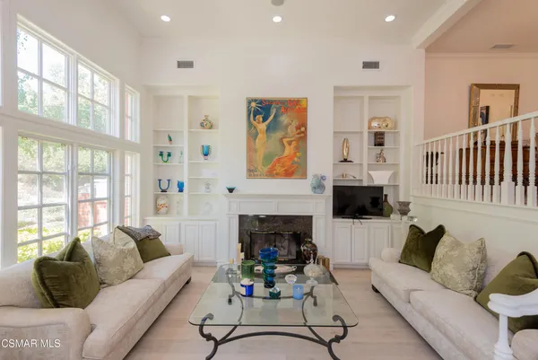 a living room with furniture a fireplace and a large window