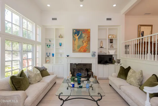 a living room with furniture a fireplace and a large window