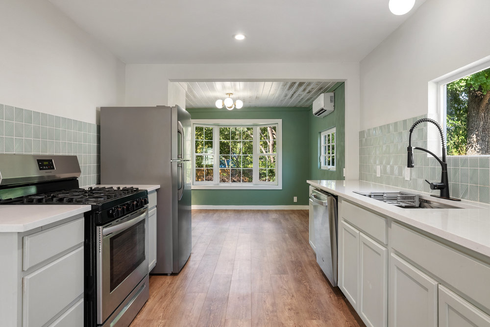 1176 Graham Street Austin, TX 78702 - Photo 6 of 20 a kitchen with a stove and a wooden floors