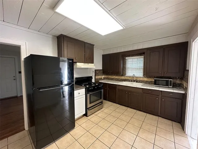 a kitchen with stainless steel appliances a stove a refrigerator and cabinets