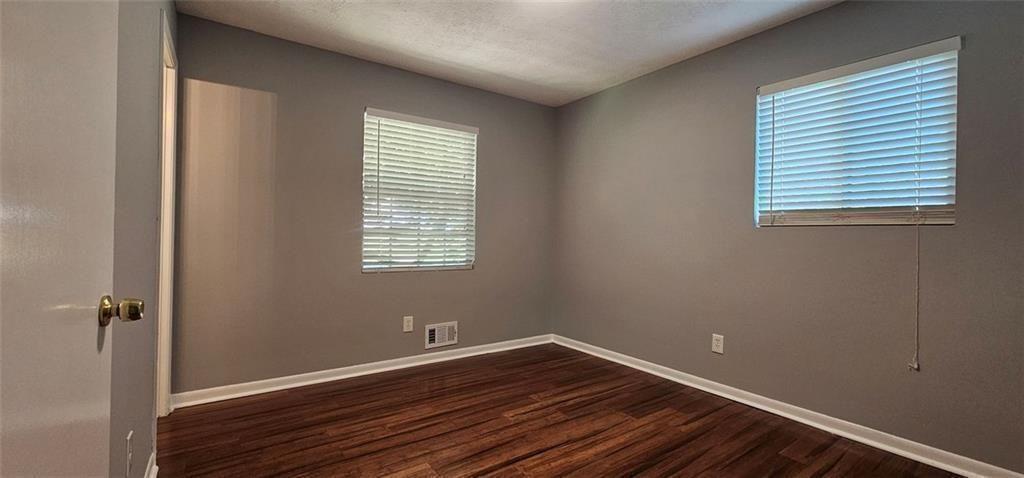 1096 Deleon Court Clarkston, GA 30021 - Photo 31 of 59 an empty room with wooden floor and windows
