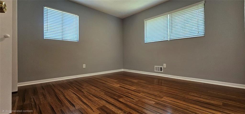 1096 Deleon Court Clarkston, GA 30021 - Photo 32 of 59 an empty room with wooden floor and windows
