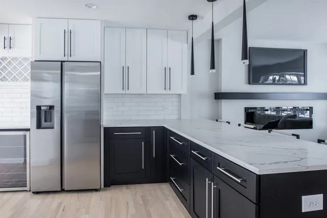 a kitchen with stainless steel appliances granite countertop a refrigerator a sink and a stove