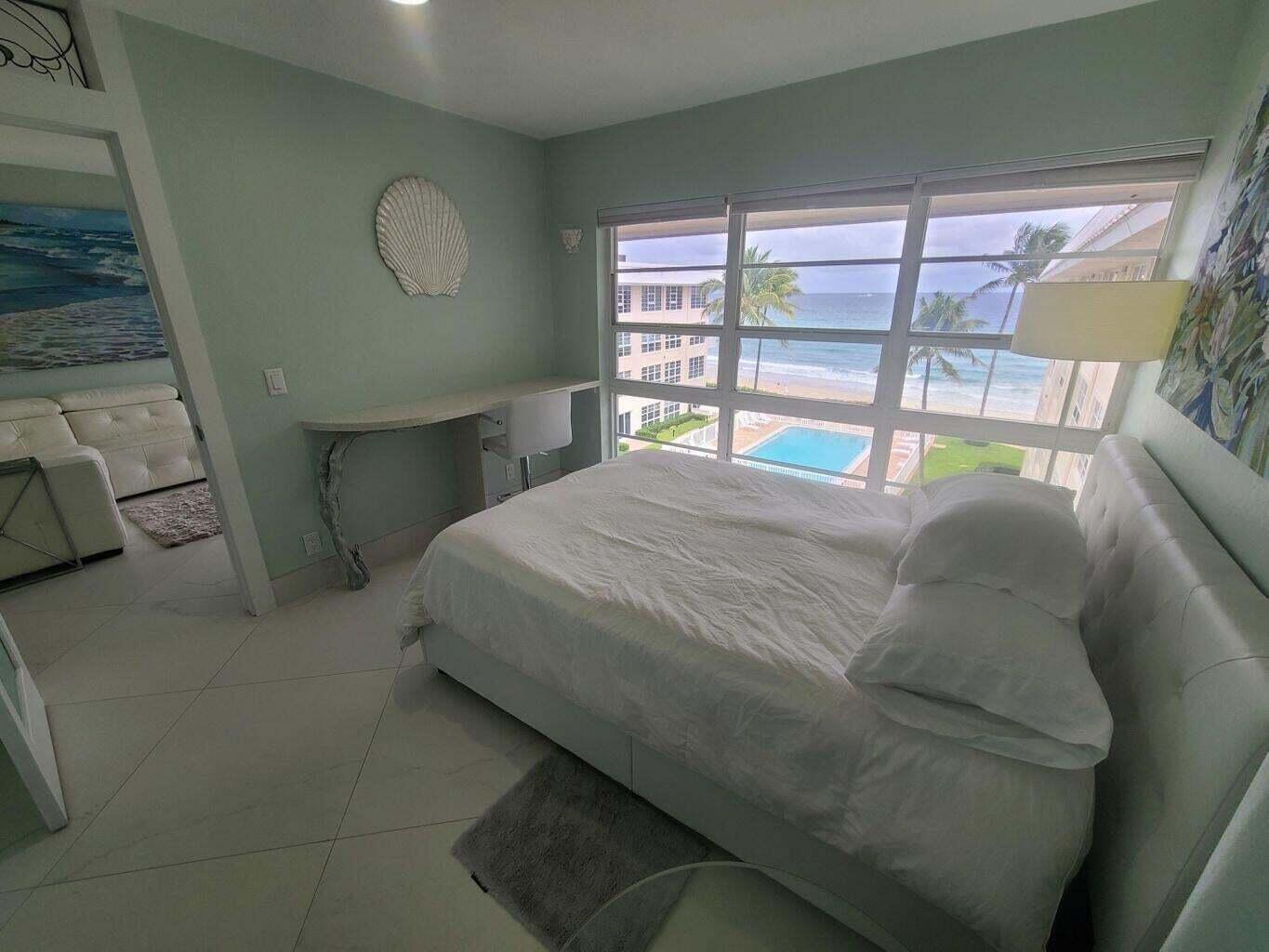 3851 North Ocean Boulevard, Unit 409 Gulf Stream, FL 33483 - Photo 11 of 29 a bedroom with a bed and a large window