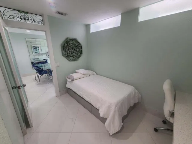 a bedroom with a bed and a chair in it