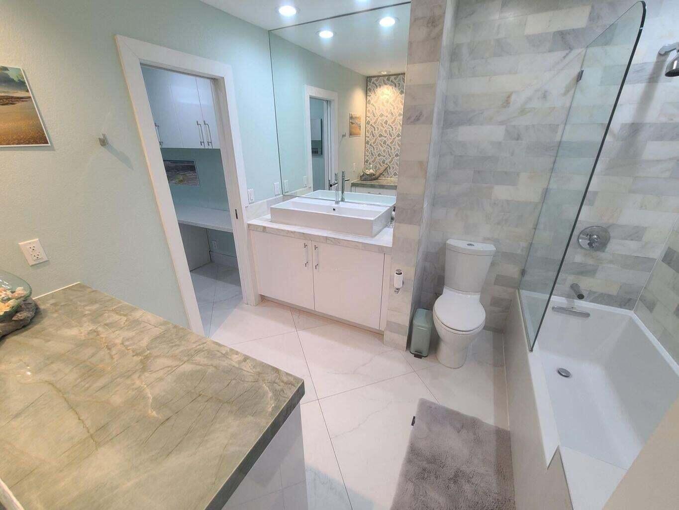 3851 North Ocean Boulevard, Unit 409 Gulf Stream, FL 33483 - Photo 18 of 29 a bathroom with a sink a toilet and mirror