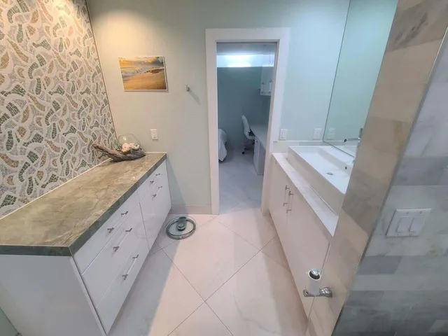 a bathroom with a granite countertop sink a toilet and shower