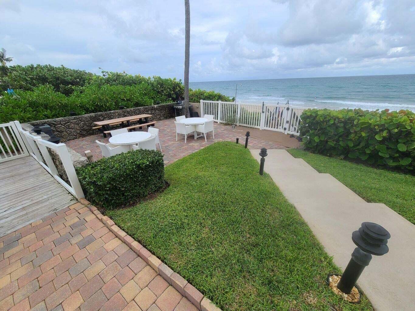 3851 North Ocean Boulevard, Unit 409 Gulf Stream, FL 33483 - Photo 23 of 29 a view of a patio with a table chairs and a patio