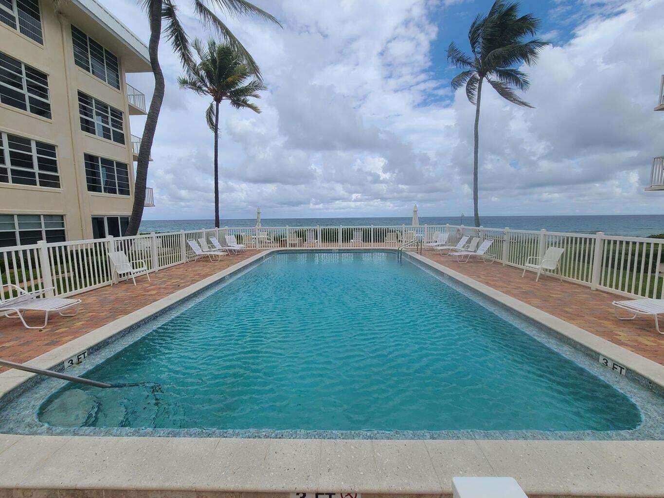 3851 North Ocean Boulevard, Unit 409 Gulf Stream, FL 33483 - Photo 24 of 29 a view of a swimming pool with a yard