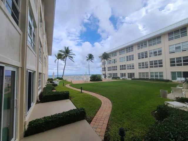 a view of a big building with a big yard and potted plants