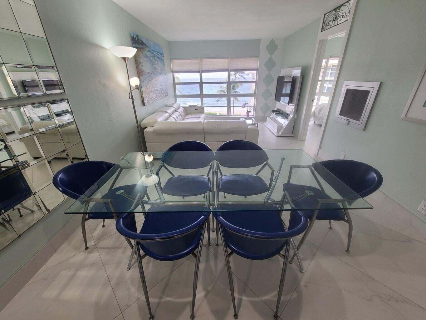 3851 North Ocean Boulevard, Unit 409 Gulf Stream, FL 33483 - Photo 7 of 29 a living room with furniture a rug and a chandelier