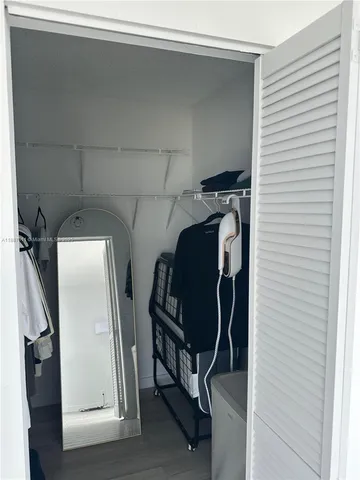 a view of walk in closet with clothes and shoes