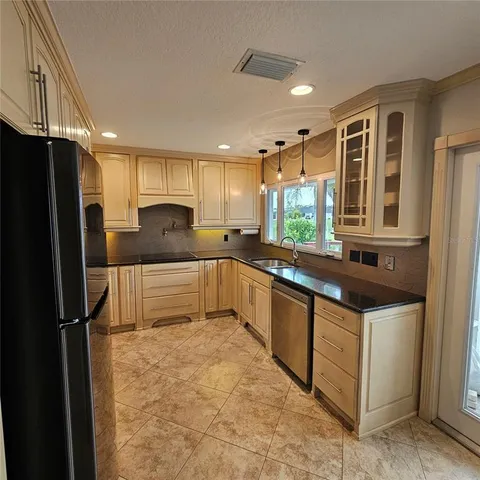 a kitchen with stainless steel appliances granite countertop a refrigerator and a sink