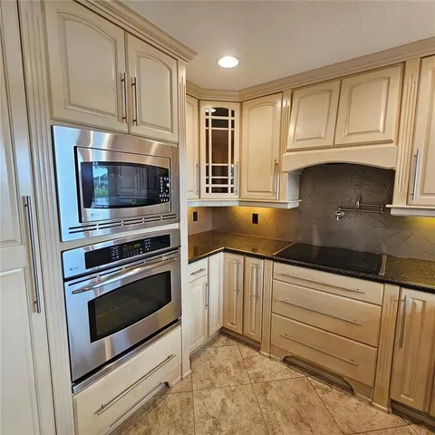 a kitchen with granite countertop a stove microwave and sink