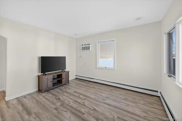 an empty room with wooden floor and furniture