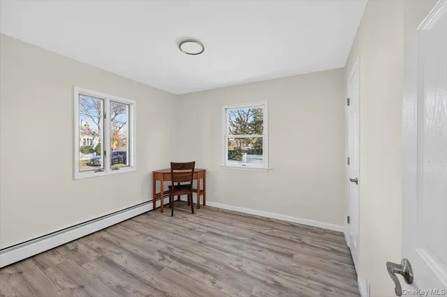 a view of a workspace with furniture and a window