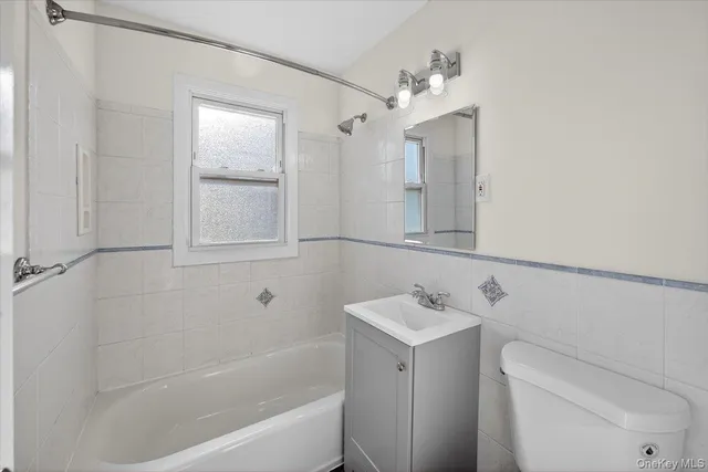 a bathroom with a bathtub sink vanity and mirror