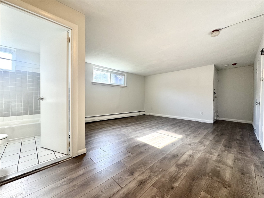 16 Vinal Street, Unit B2 Boston, MA 02135 - Photo 6 of 13 a view of a room with wooden floor and white walls